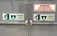 Señales fotoluminiscentes instaladas en puerta de seguridad